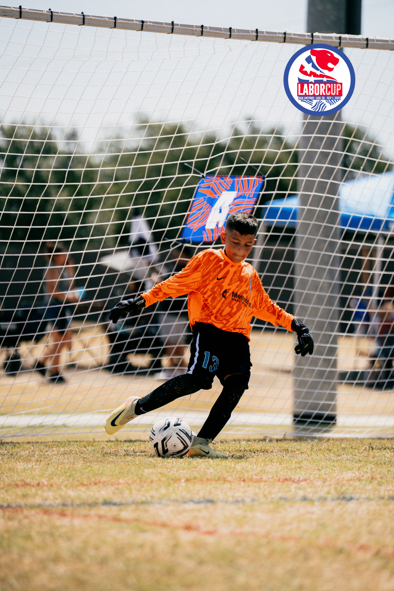 Goalkeeper in orange playing the ball at the San Antonio Labor Cup